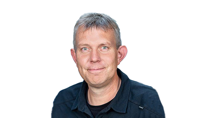 Portrait eines Mitarbeiters mit kurzem Haar in einem dunklen Hemd.